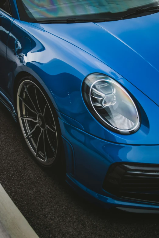 a blue sports car is parked near a curb