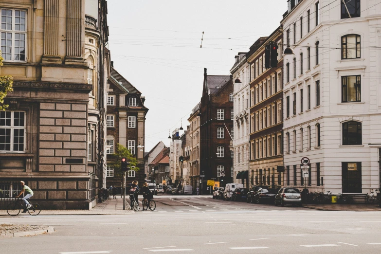 a group of buildings next to a street with people on bicycles