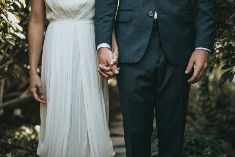 the bride and groom are holding hands