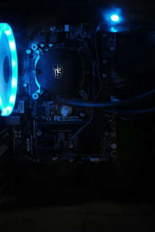 the inside of a computer case with a glowing neon fan