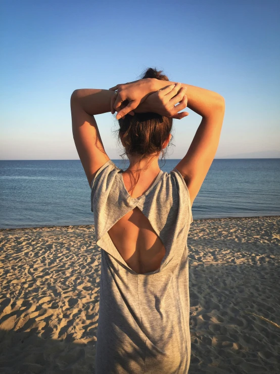 a woman in a gray top on the beach