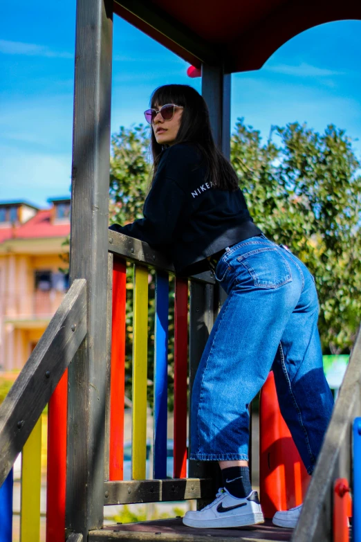 a woman in jeans standing on a colorful playground