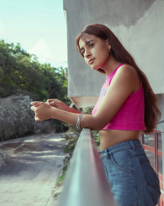 a woman wearing high waisted jeans leaning on a building