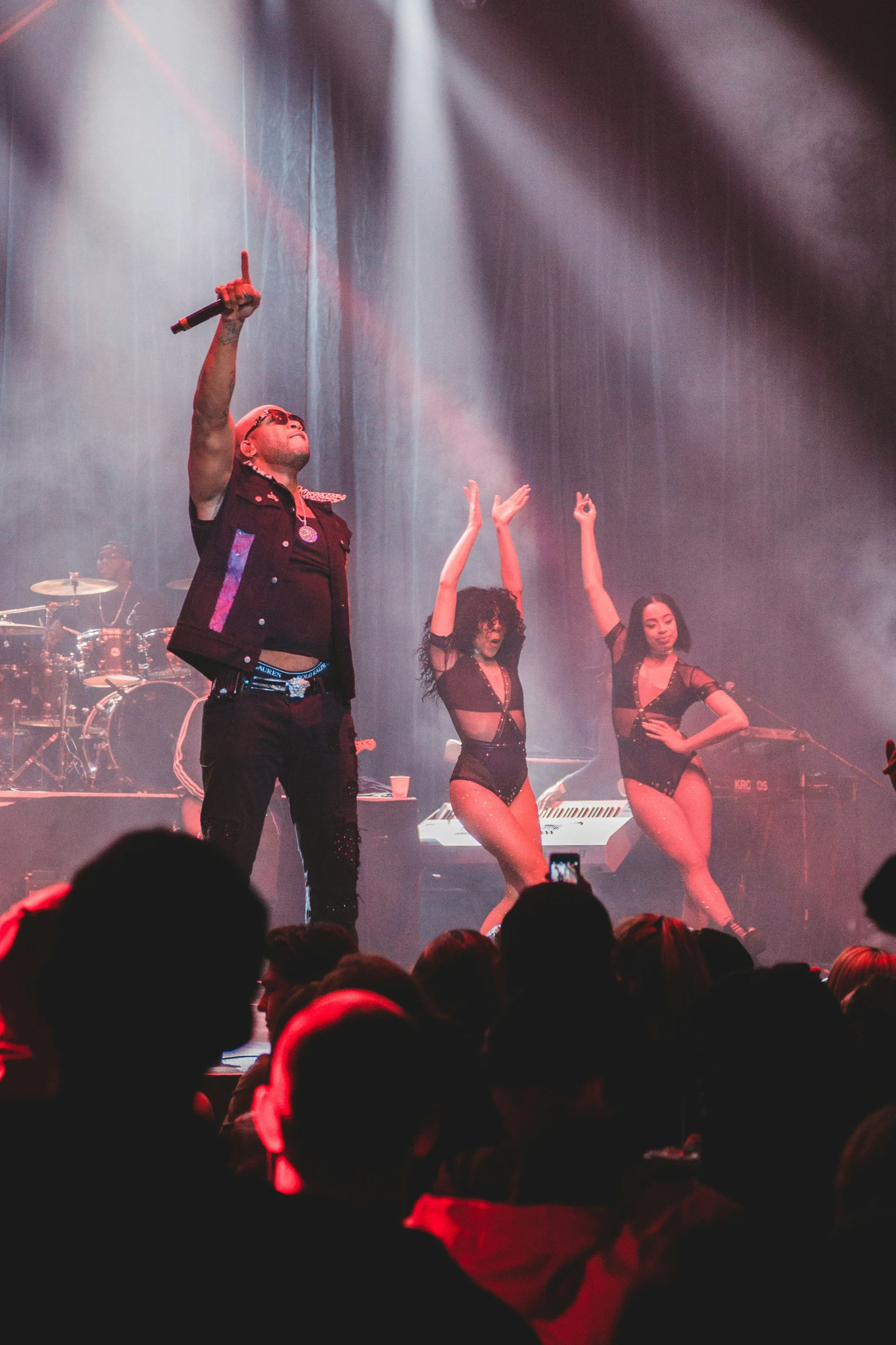 a man standing on top of a stage wearing a suit and jeans