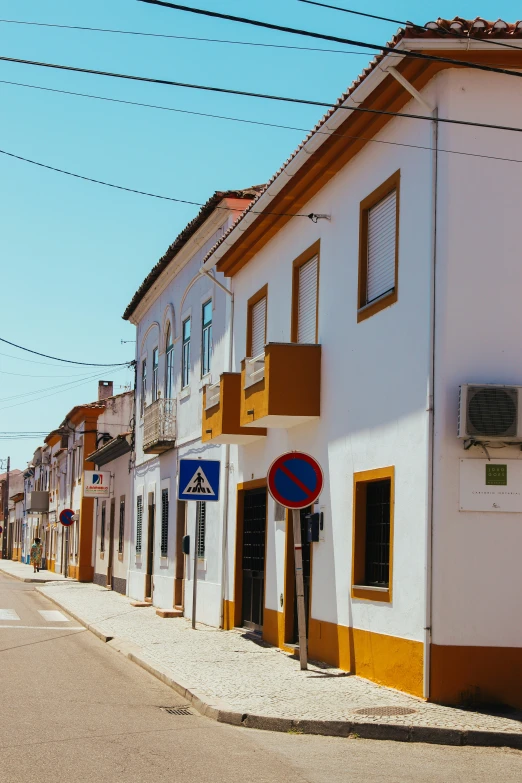 a city street with white buildings and some brown windows