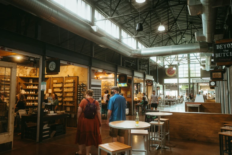 two people walking through a store filled with furniture