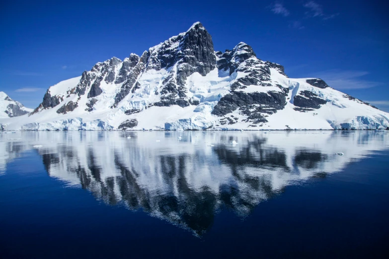 a very large mountain sitting above some blue water