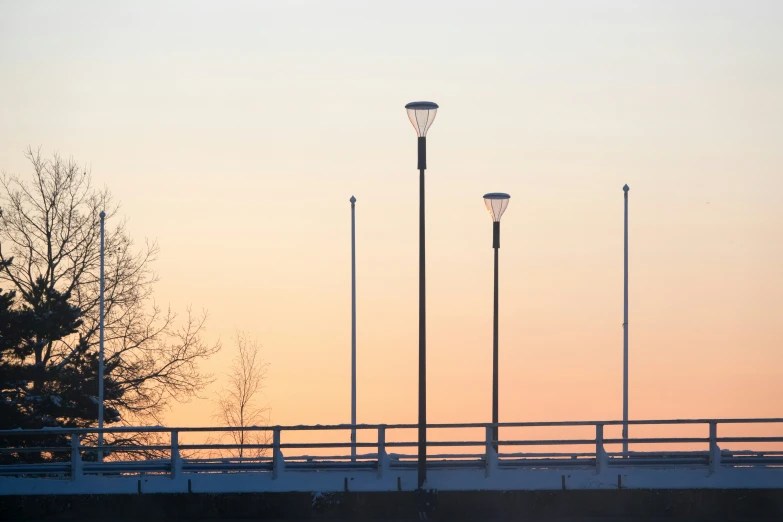 a line of light poles sitting next to a white bridge