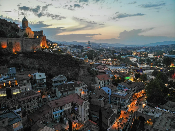 this city is lit up and looking down on the hill