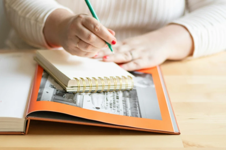 a woman is doing notes on a book