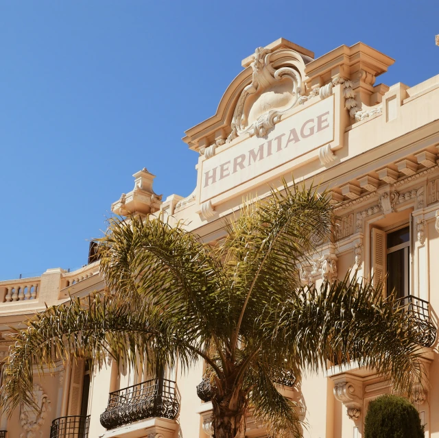 a building with large balcony and palm trees