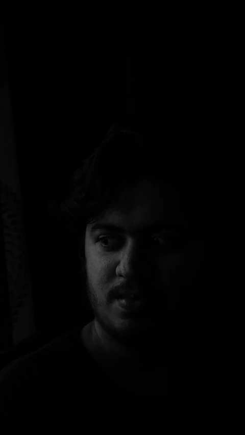 a black and white image of a man in a dark room