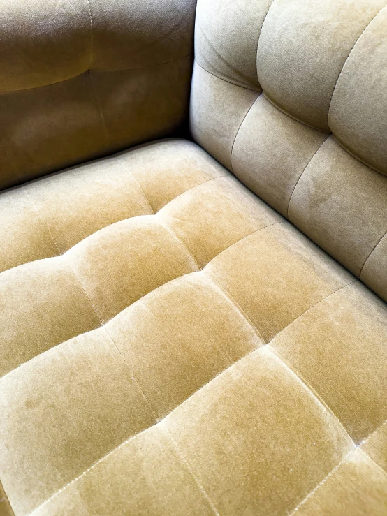 a tan upholstered couch sitting on top of a floor