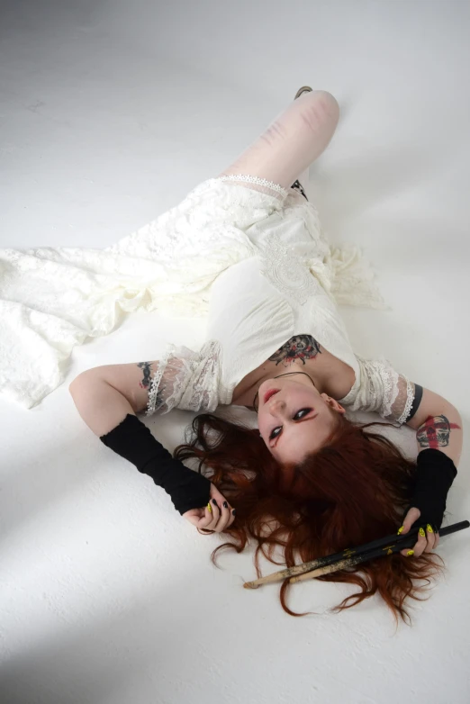 a woman with red hair laying on the ground