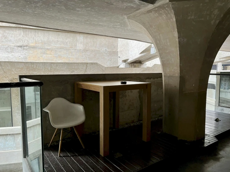 a small dining table next to a white chair in an enclosed room