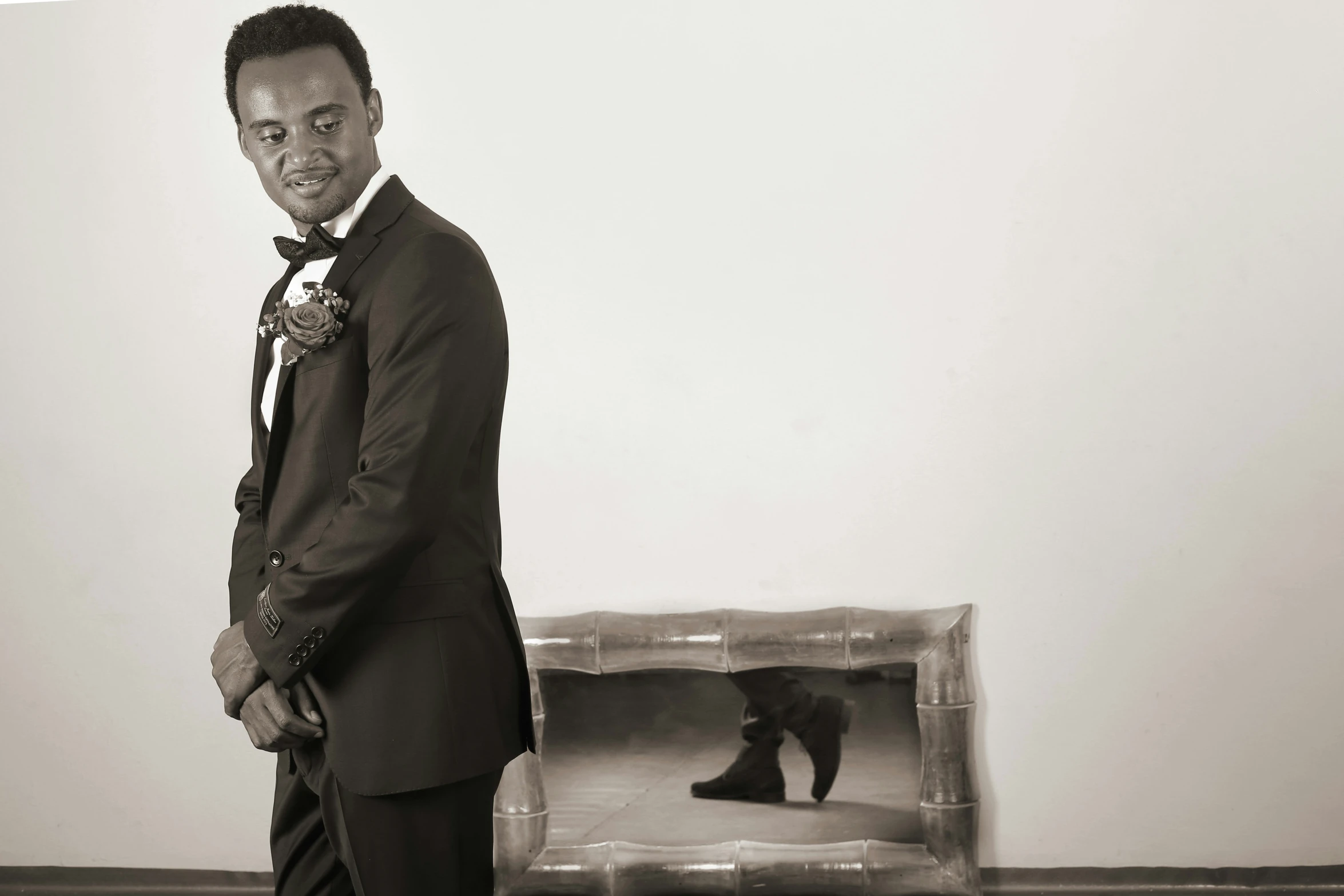 a man in suit and bow tie standing in front of two framed black bears