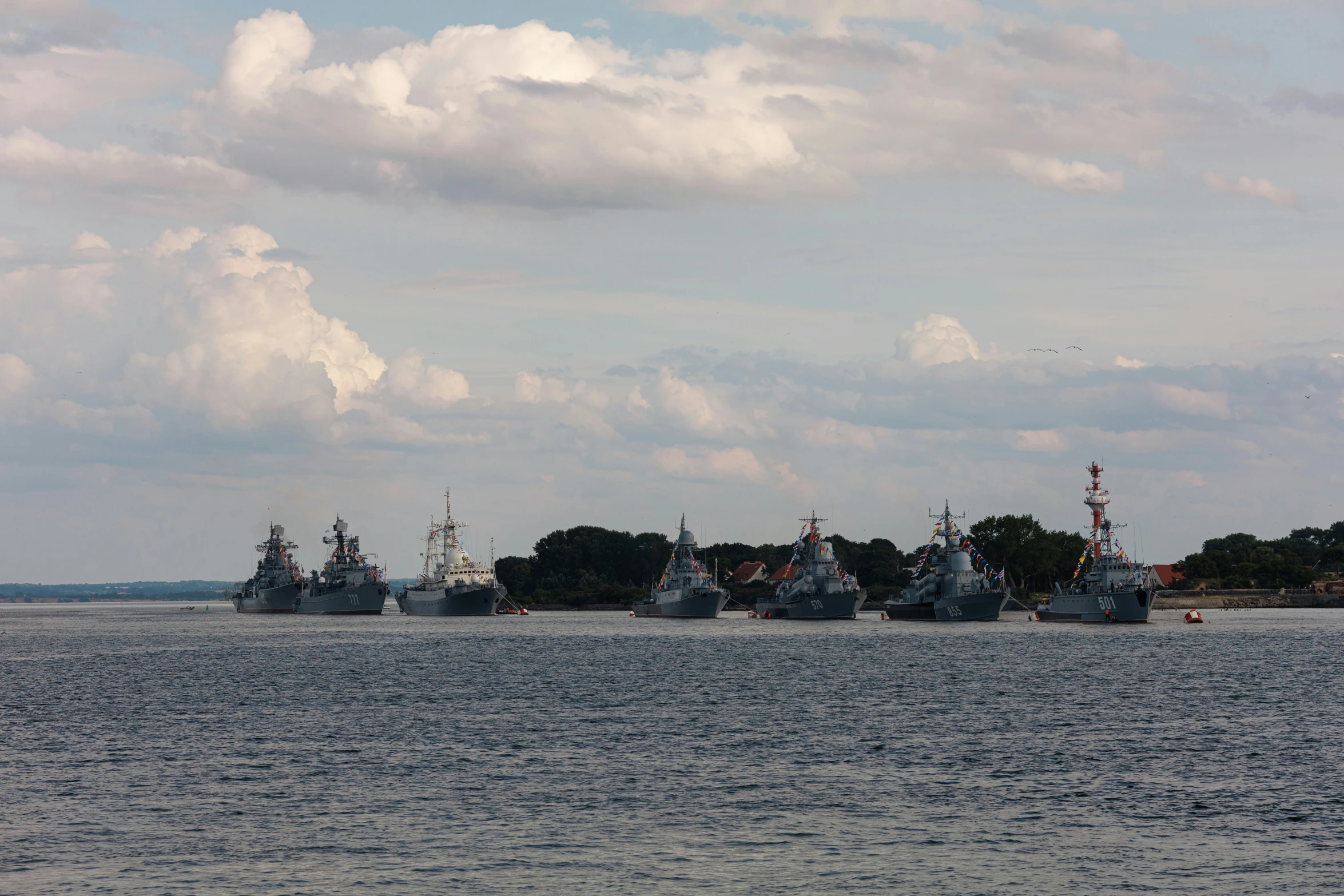 several ships in the water, docked on land