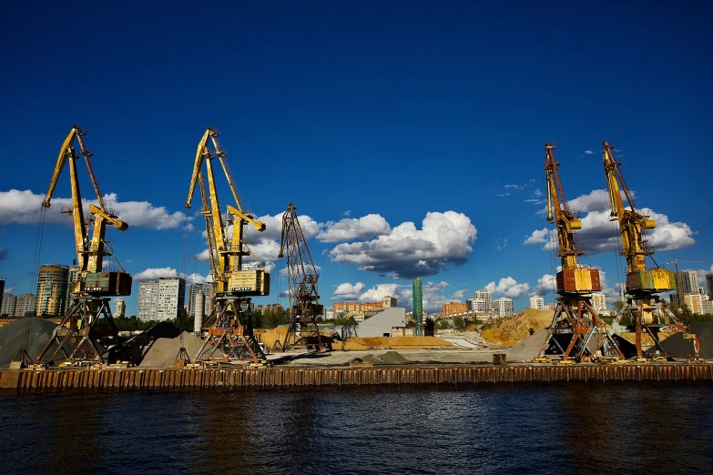 a group of cranes sitting next to a lake