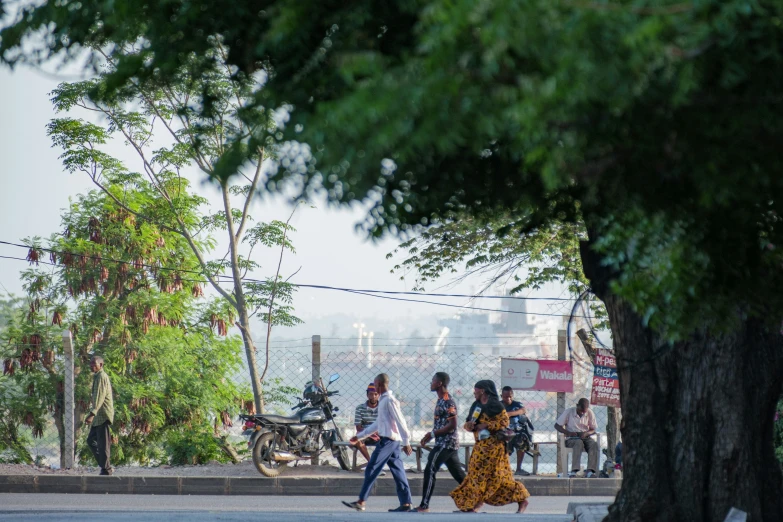 people walking down the street with bicycles and buildings behind them