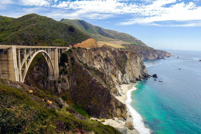 the bridge is on the side of a big cliff near the ocean