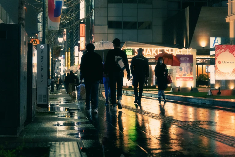several people walking on the street with rain pouring down