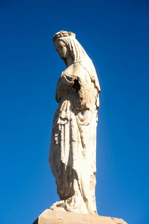 the back of a statue looking up in the blue sky