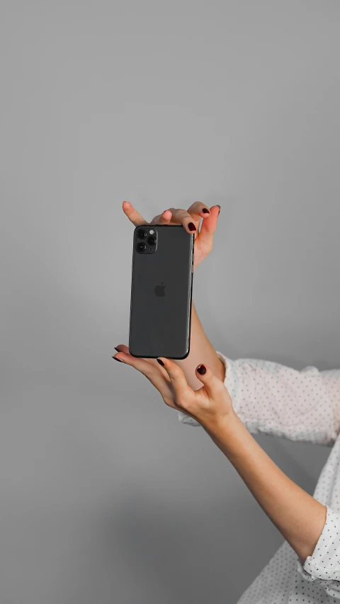 a woman holding up an iphone in her hand