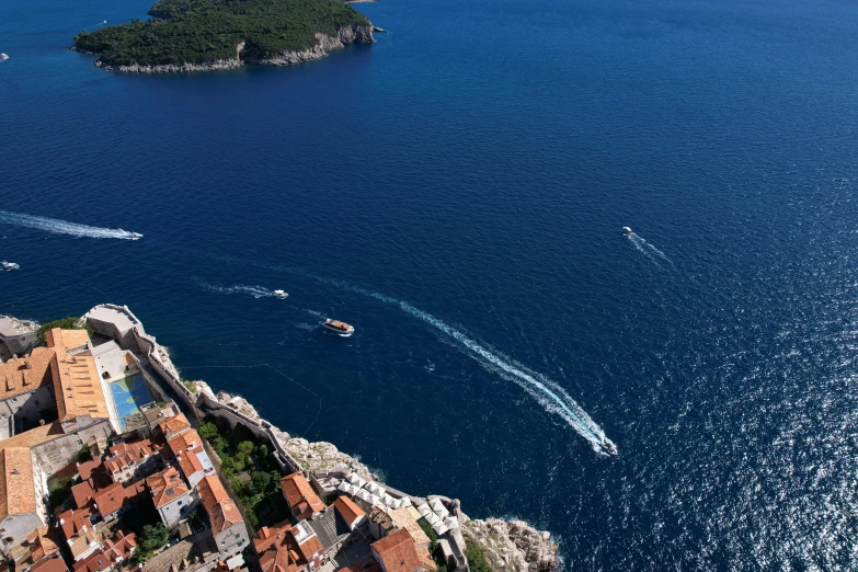 there are two boats in the water by this small island