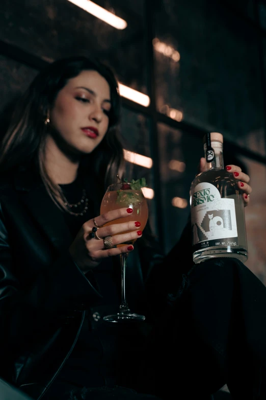 a lady with red nails holding a tall cocktail glass