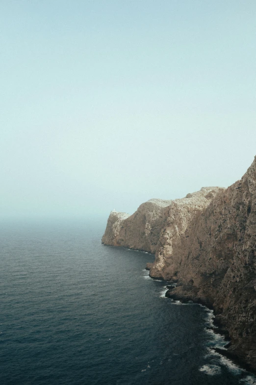 a view of the water off of a cliff near water