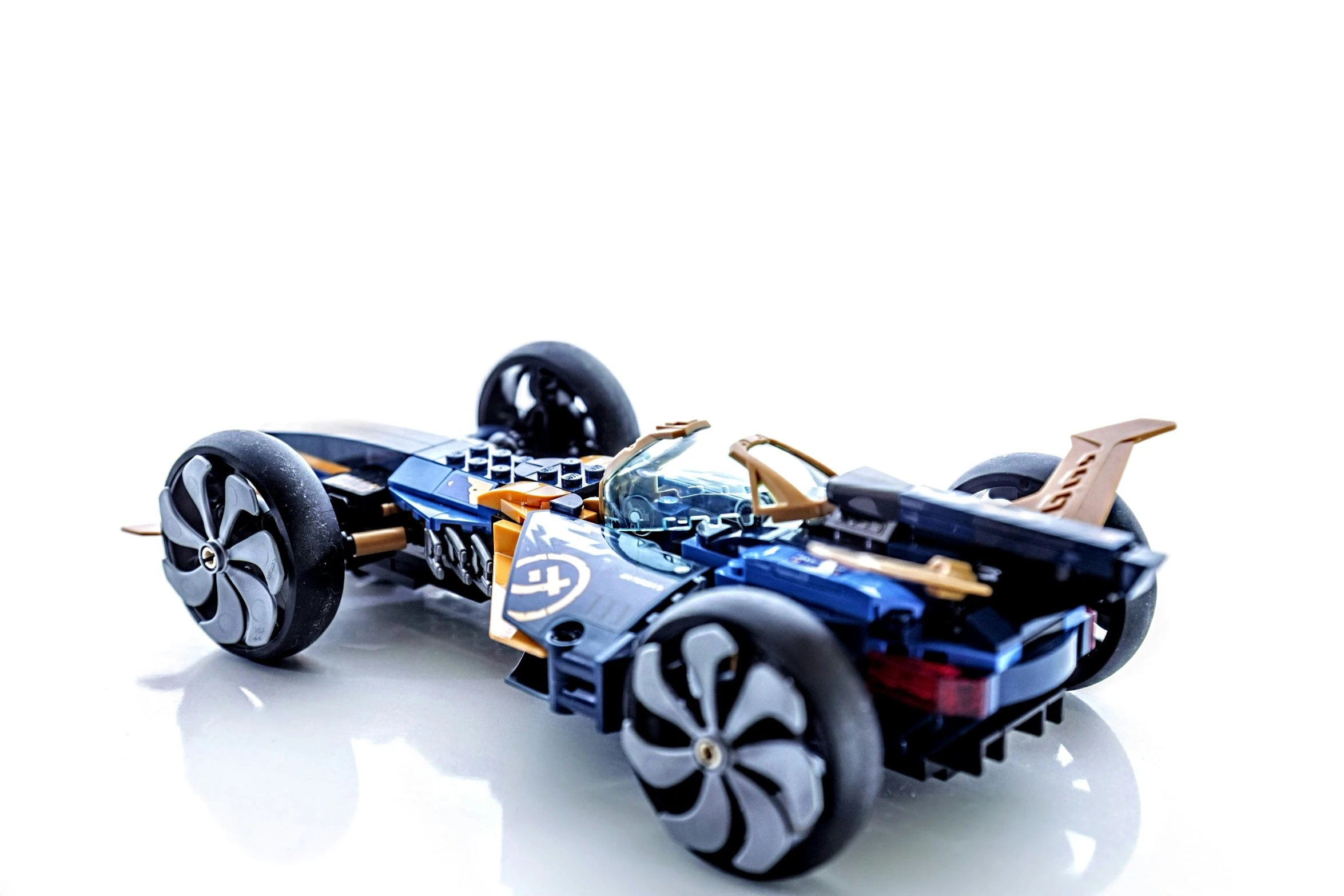 a toy car with three wheels on a white surface