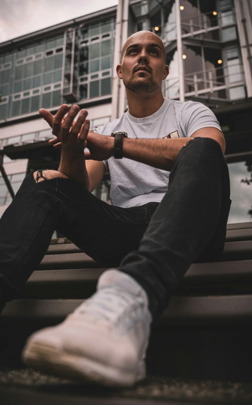 man sitting in front of an apartment building