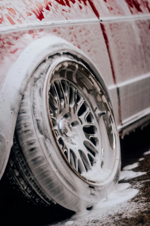 a wheel and tire in the snow with graffiti