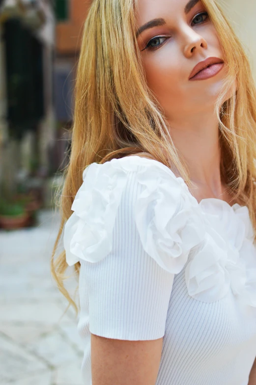 woman in white top with red hair looking up