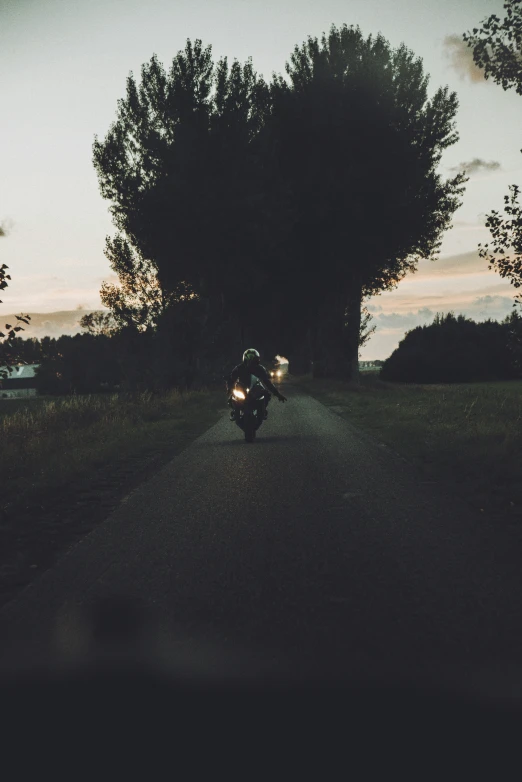 a motorcycle driver on a road during the night