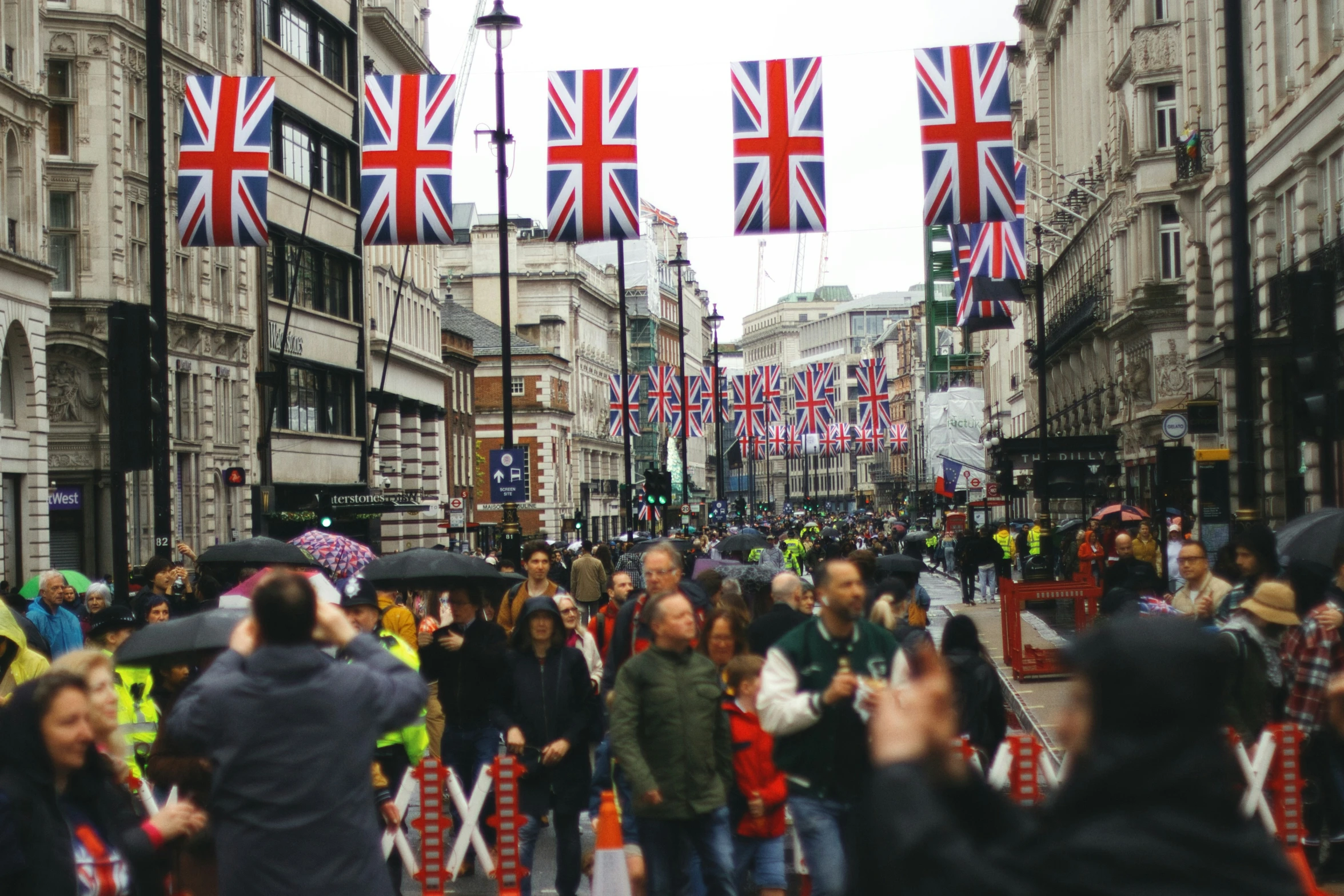 a busy street with lots of flags hanging over it