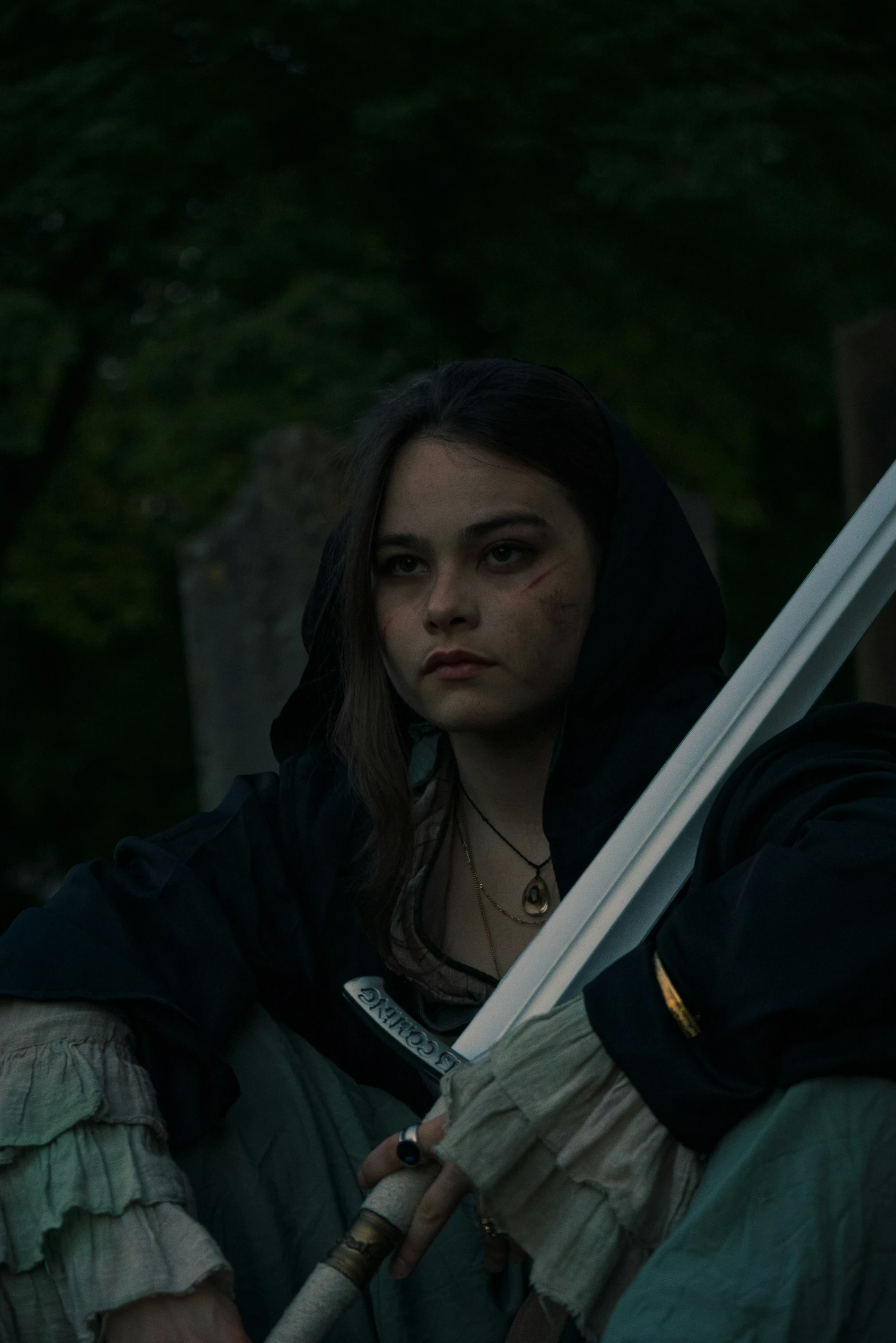 a woman holding a sword with long sleeves