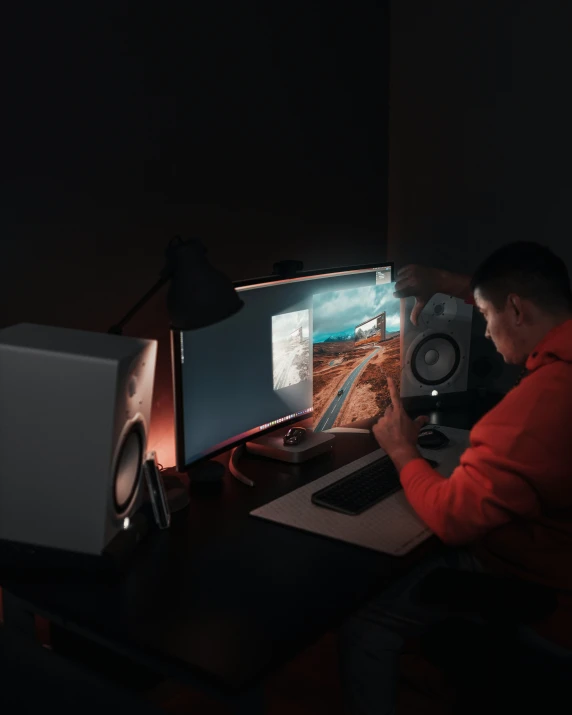 a man sitting at a computer monitor working on the screen