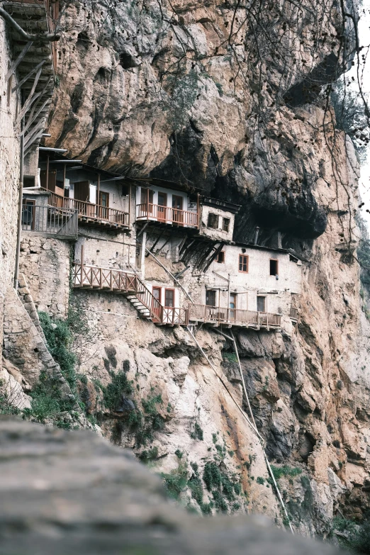 a stone cliff with houses built in it