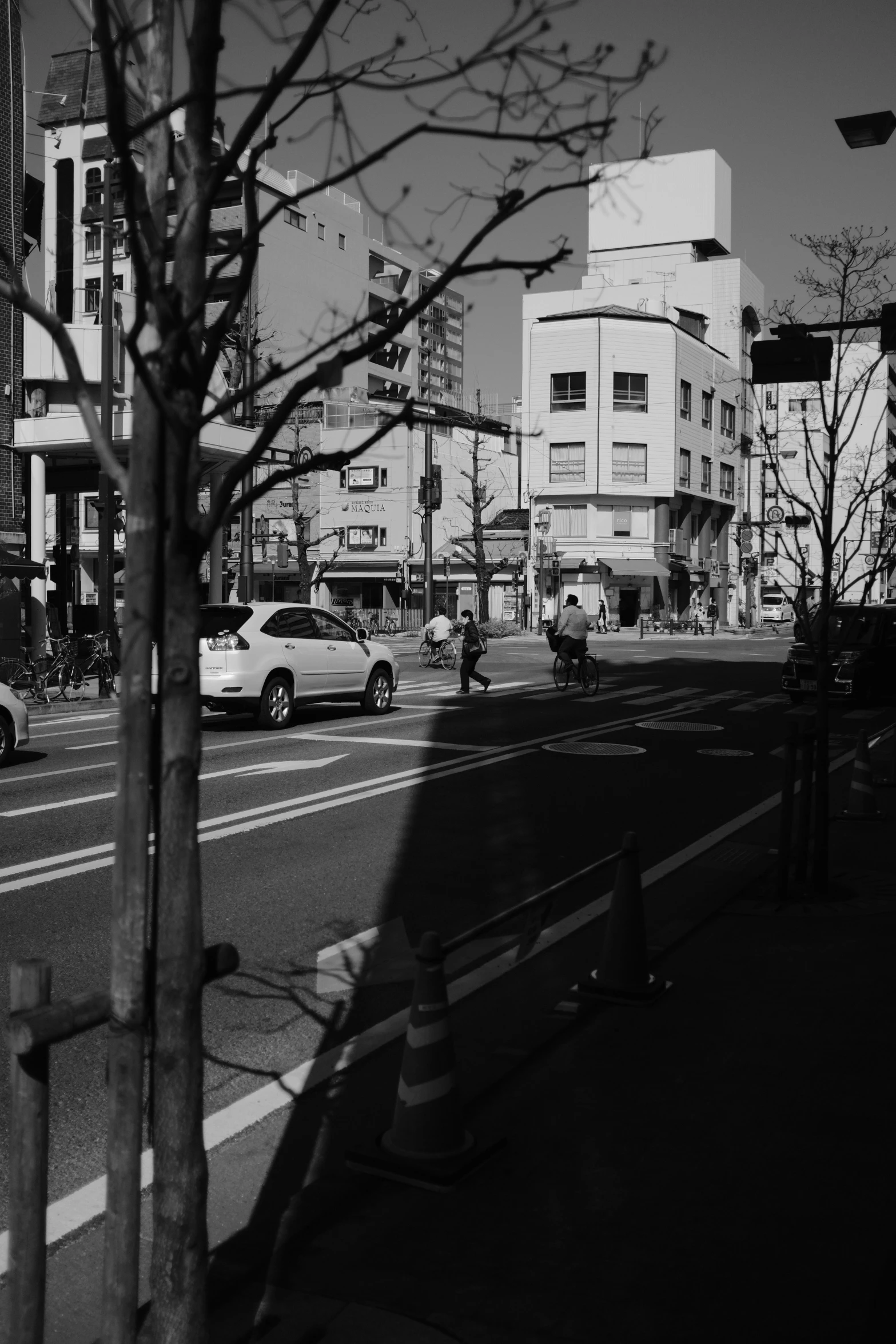 cars driving down a road next to tall buildings