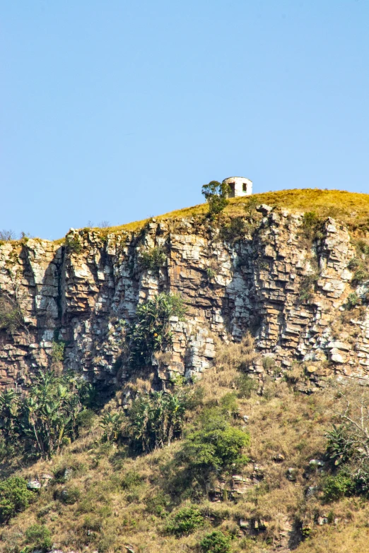 a large structure with rocks sits on a cliff