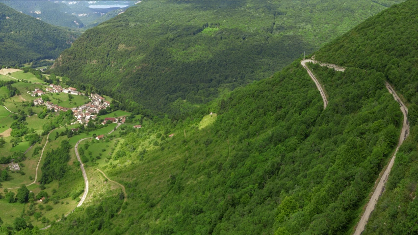 a picture from the air of a road winding into a village