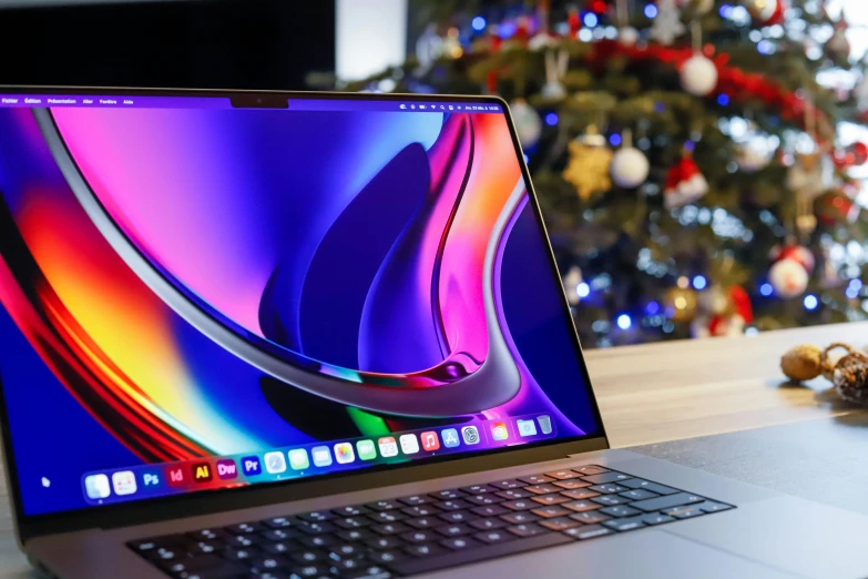 a laptop computer sitting on a table with a christmas tree in the background