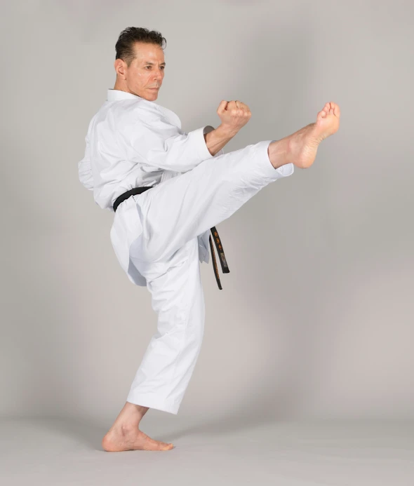 a man is doing a kick pose for the camera
