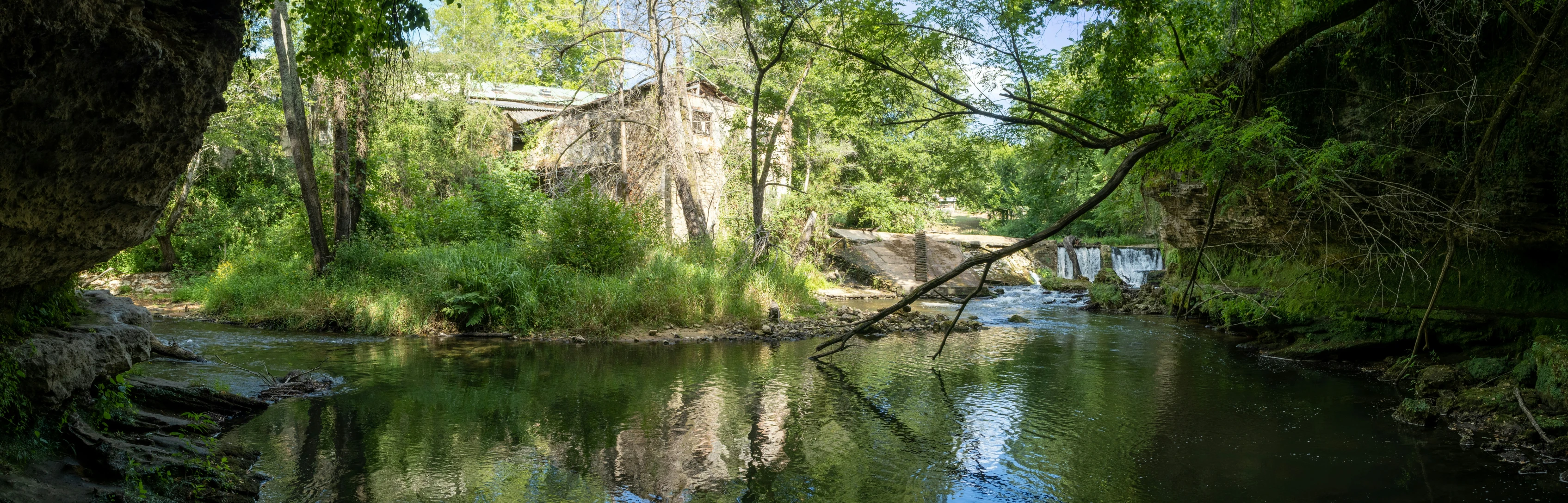 a river and tree filled trees are shown from far away