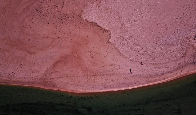 an aerial po of a red beach with black sand