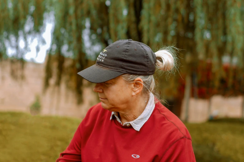 an older woman with ponytails wearing a red shirt