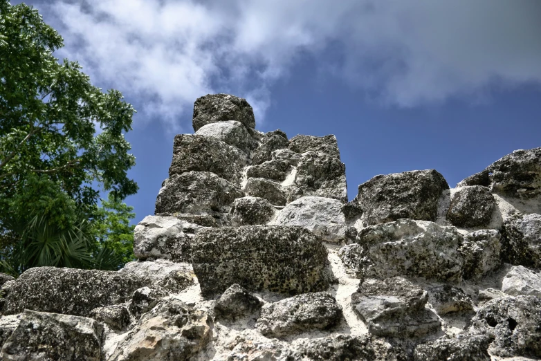 a large mountain covered in gray rocks under a blue sky