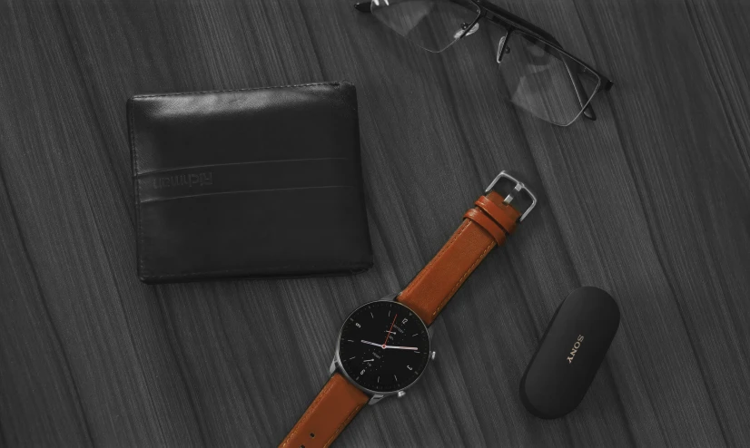 a watch and a wallet on top of a table