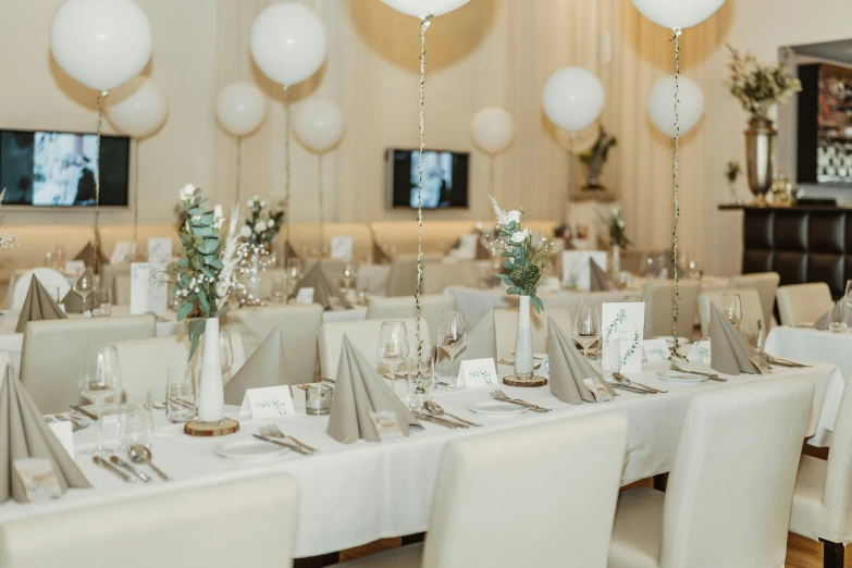 a long table with several tables with place settings on them